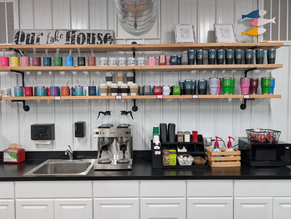 The coffee corner at Mt Mariah Market with espresso machine and lake-themed tumblers