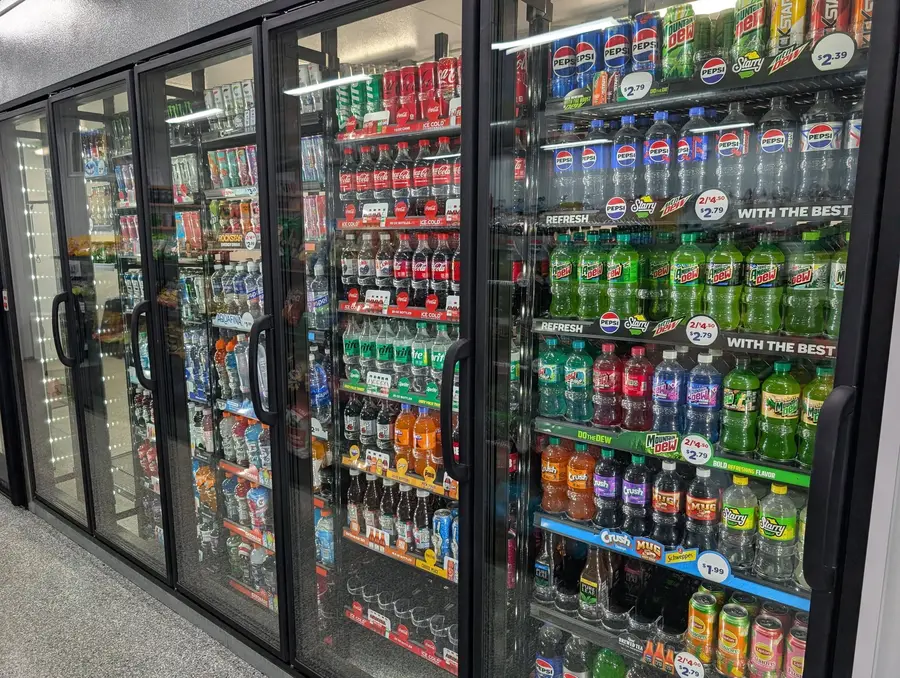 Cooler doors lined with pop, water, and energy drinks
